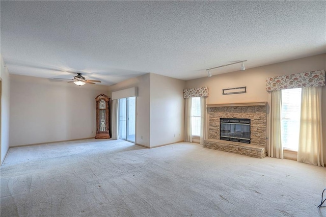 17800 E Bolger Rd Unit 245-A, Independence, MO 64055 - unfurnished living room with carpet floors, ceiling fan, a fireplace, a textured ceiling, and baseboards