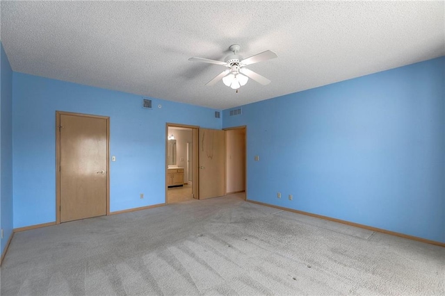 17800 E Bolger Rd Unit 245-A, Independence, MO 64055 - unfurnished bedroom featuring a textured ceiling, carpet, baseboards, connected bathroom, and a ceiling fan