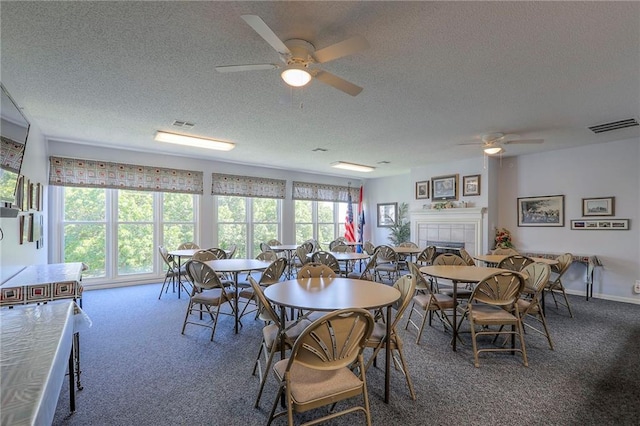 17800 E Bolger Rd Unit 245-A, Independence, MO 64055 - carpeted dining space with a ceiling fan, a textured ceiling, and a tiled fireplace