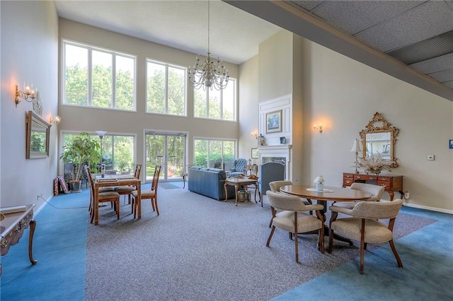 17800 E Bolger Rd Unit 245-A, Independence, MO 64055 - dining room featuring carpet flooring, a towering ceiling, a fireplace, a chandelier, and baseboards