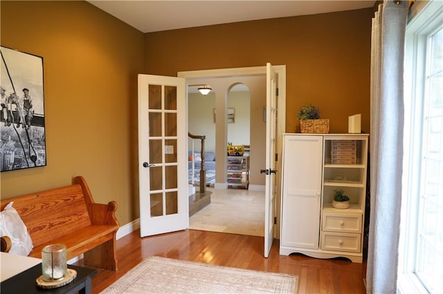 interior space with baseboards, french doors, and wood finished floors