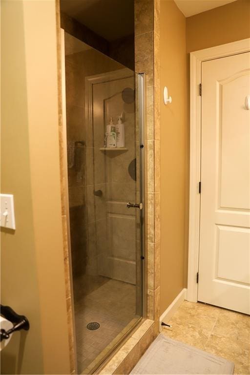 bathroom featuring baseboards and a stall shower