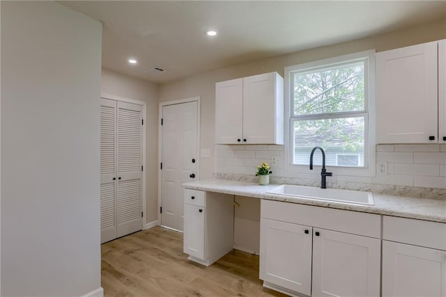 812 S Saville St, Independence, MO 64050 - kitchen with a sink, tasteful backsplash, light wood finished floors, white cabinetry, and recessed lighting