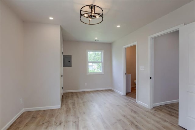 812 S Saville St, Independence, MO 64050 - empty room with electric panel, light wood-type flooring, baseboards, recessed lighting, and a chandelier