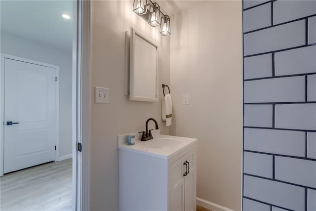 812 S Saville St, Independence, MO 64050 - bathroom with wood finished floors, baseboards, and vanity