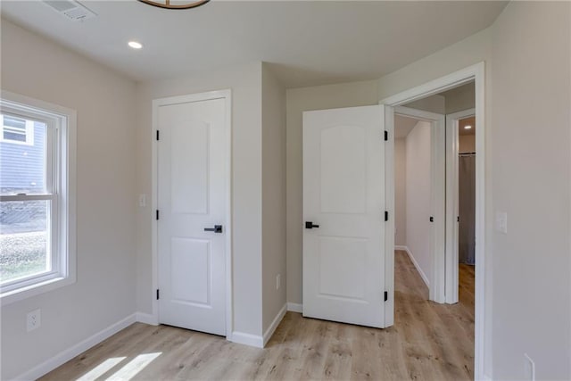 812 S Saville St, Independence, MO 64050 - unfurnished bedroom with multiple windows, light wood-type flooring, baseboards, and recessed lighting