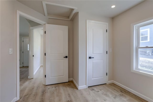 812 S Saville St, Independence, MO 64050 - hallway with light wood finished floors, baseboards, and attic access