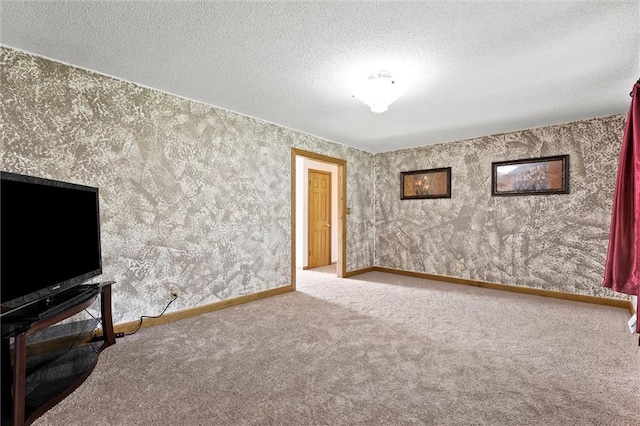 unfurnished living room featuring a textured ceiling, wallpapered walls, baseboards, and carpet