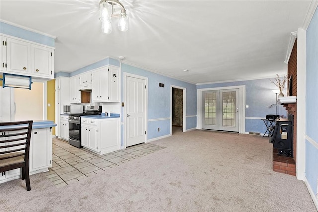 kitchen featuring white cabinets, open floor plan, ornamental molding, light carpet, and stainless steel appliances