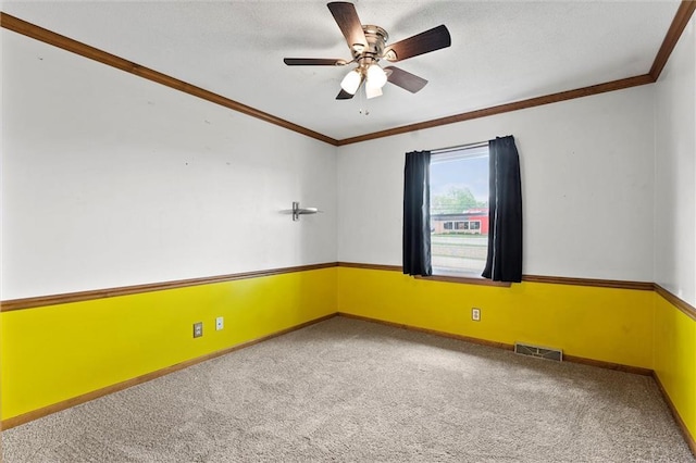 unfurnished room with visible vents, a ceiling fan, crown molding, and carpet flooring