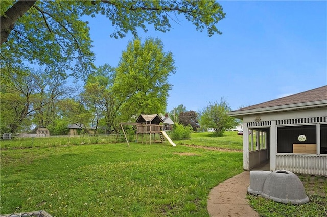 view of yard with a sunroom and a playground