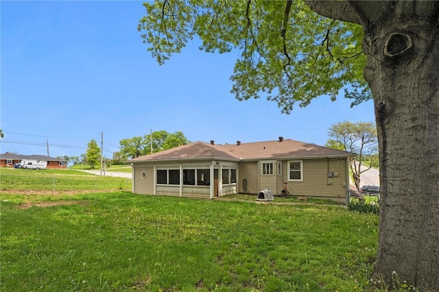 rear view of house featuring a lawn