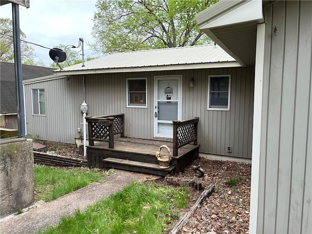 doorway to property featuring covered porch and metal roof