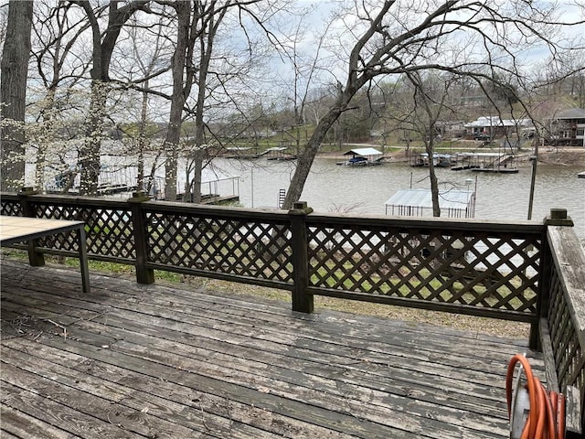 wooden deck with a water view and a boat dock