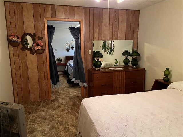 bedroom featuring wood walls and dark colored carpet