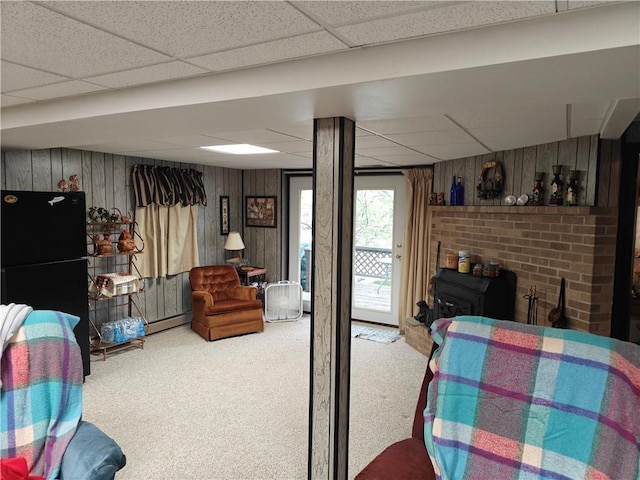 bedroom featuring carpet, a drop ceiling, and wooden walls
