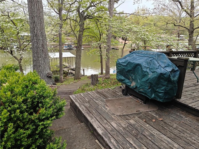 wooden deck with a water view and a boat dock
