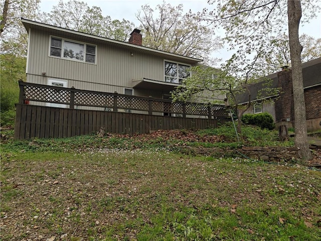 rear view of house featuring fence and a chimney