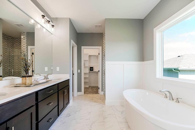 12541 S Hedge Ct, Olathe, KS 66061 - bathroom with marble finish flooring, a freestanding tub, a walk in closet, double vanity, and a shower stall