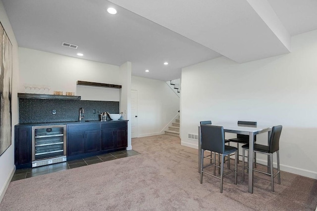 12541 S Hedge Ct, Olathe, KS 66061 - dining space featuring wine cooler, bar with sink, stairway, recessed lighting, and baseboards