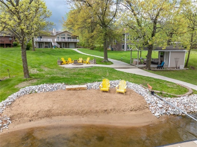 surrounding community with a lawn, an outdoor structure, an outdoor fire pit, and a wooden deck