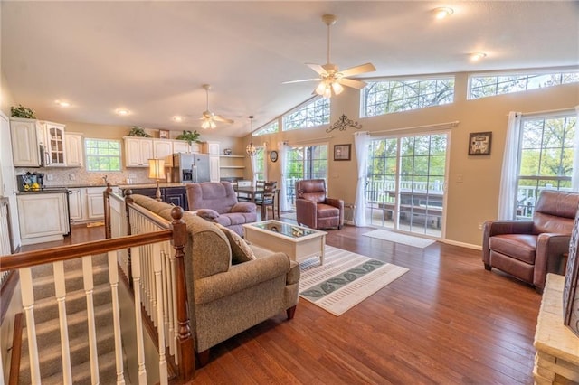 living room featuring ceiling fan, dark wood-style floors, baseboards, and lofted ceiling