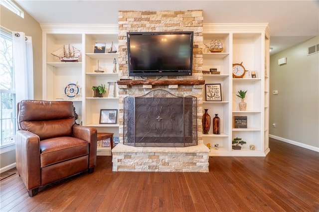 living room featuring baseboards, hardwood / wood-style flooring, and built in shelves