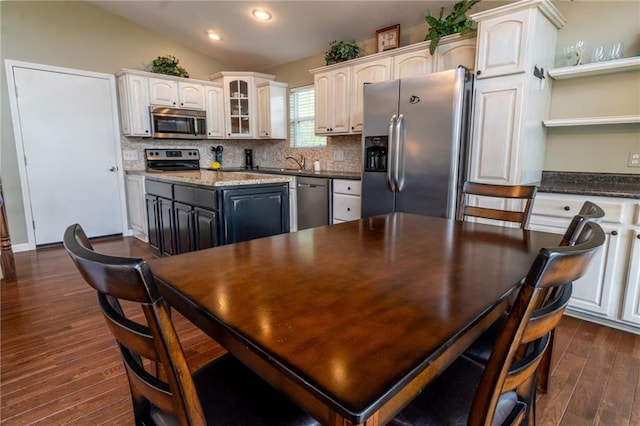 kitchen with appliances with stainless steel finishes, tasteful backsplash, dark wood finished floors, a sink, and recessed lighting