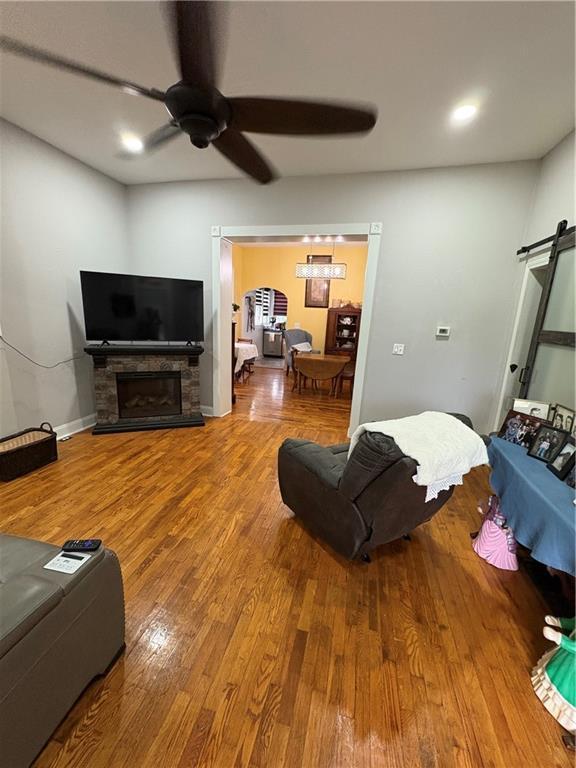 1316 Santa Fe St, Atchison, KS 66002 - living room with ceiling fan, wood finished floors, a stone fireplace, and recessed lighting
