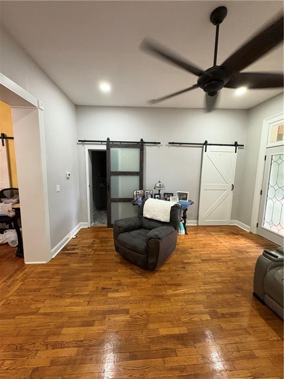 1316 Santa Fe St, Atchison, KS 66002 - living area featuring a barn door, a ceiling fan, hardwood / wood-style flooring, baseboards, and recessed lighting
