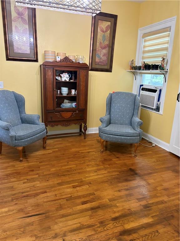 1316 Santa Fe St, Atchison, KS 66002 - living area featuring wood finished floors, baseboards, and cooling unit