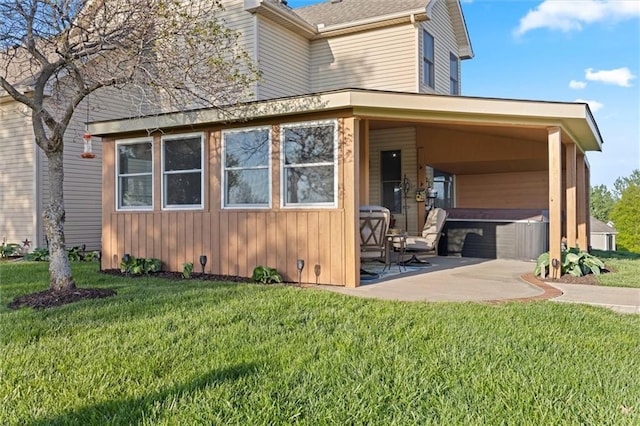 view of front of property featuring a hot tub, a patio area, and a front lawn