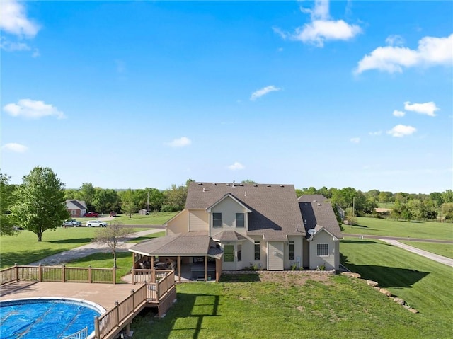 back of property featuring a lawn, fence, a fenced in pool, and roof with shingles
