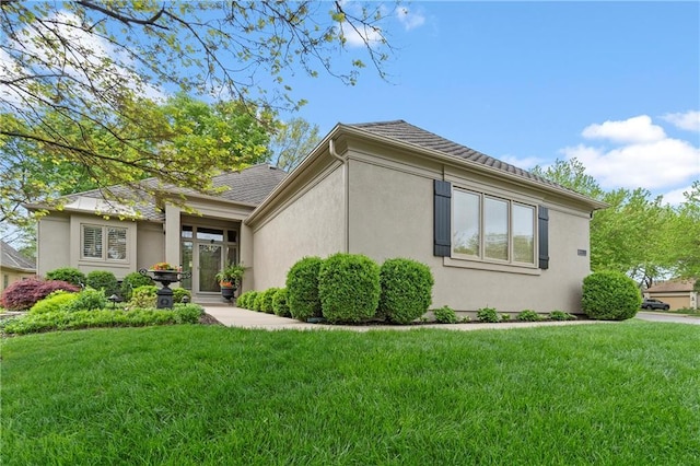 view of side of home featuring a lawn and stucco siding