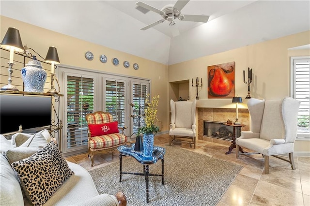 living room with french doors, high vaulted ceiling, a tiled fireplace, baseboards, and ceiling fan