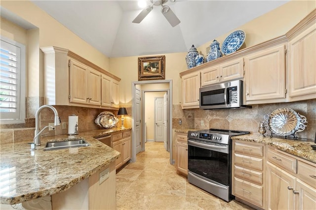 kitchen with light brown cabinets, light stone countertops, ceiling fan, a sink, and appliances with stainless steel finishes