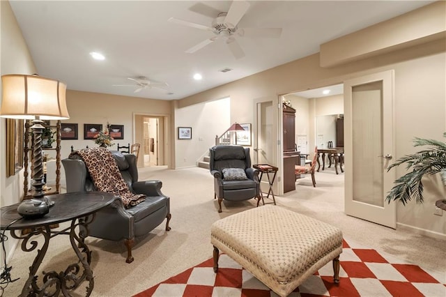 living area with recessed lighting, stairway, light carpet, a ceiling fan, and baseboards