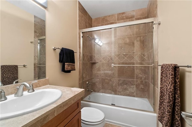 bathroom with toilet, vanity, and combined bath / shower with glass door