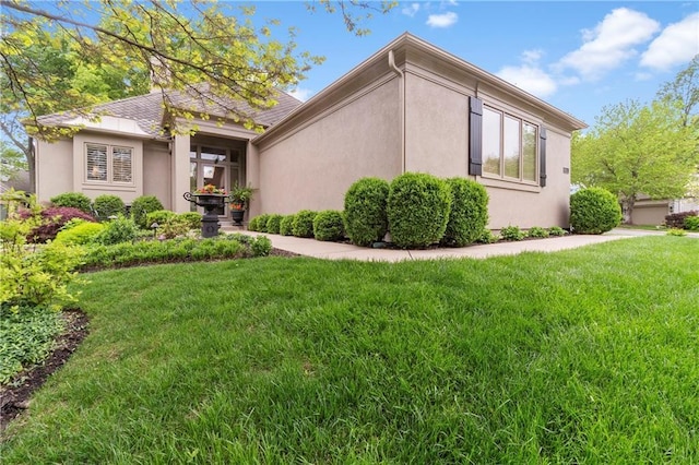 view of side of property featuring a lawn and stucco siding