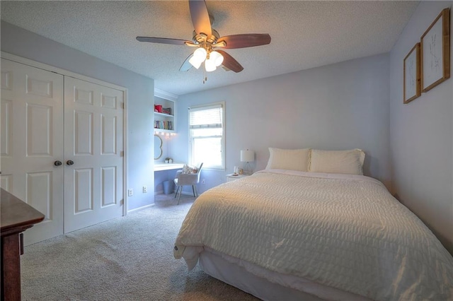 carpeted bedroom with ceiling fan, a closet, and a textured ceiling