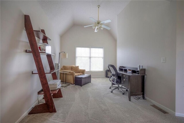 carpeted home office featuring visible vents, baseboards, a textured ceiling, a ceiling fan, and vaulted ceiling