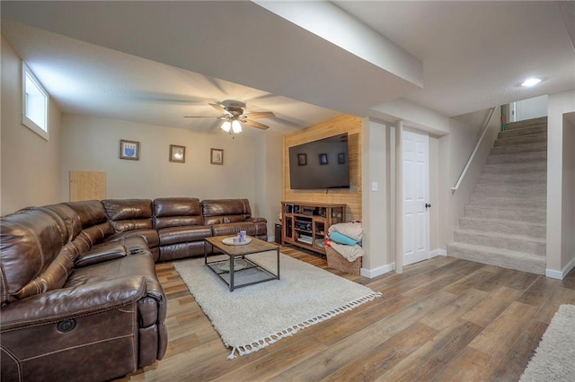 living area with stairway, baseboards, ceiling fan, and wood finished floors