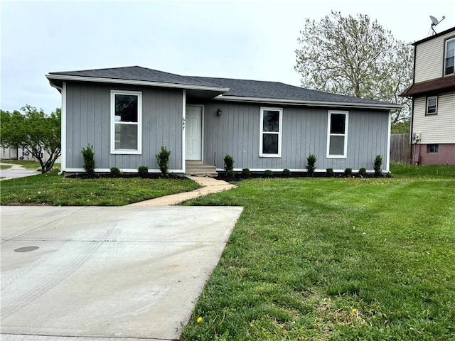 ranch-style home with board and batten siding and a front lawn