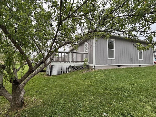 view of side of property with a deck and a yard