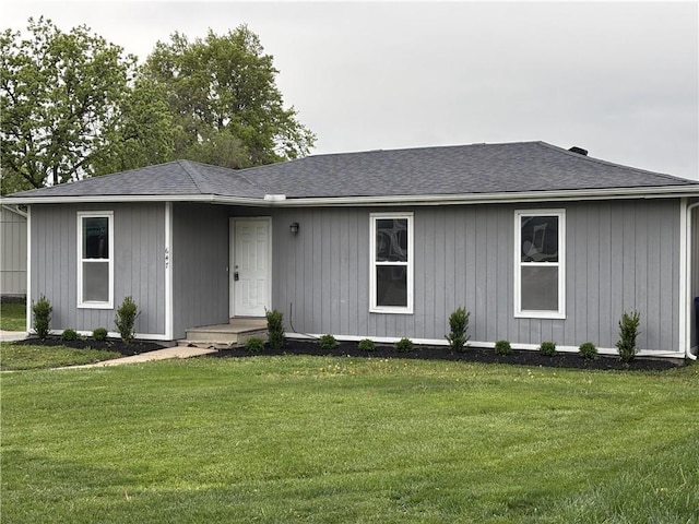 ranch-style home featuring a front yard and roof with shingles