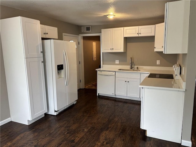 kitchen featuring white appliances, white cabinetry, a sink, dark wood-style floors, and visible vents