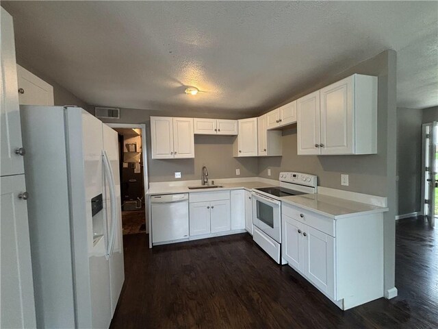 kitchen with white appliances, dark wood-style flooring, a sink, visible vents, and a textured ceiling