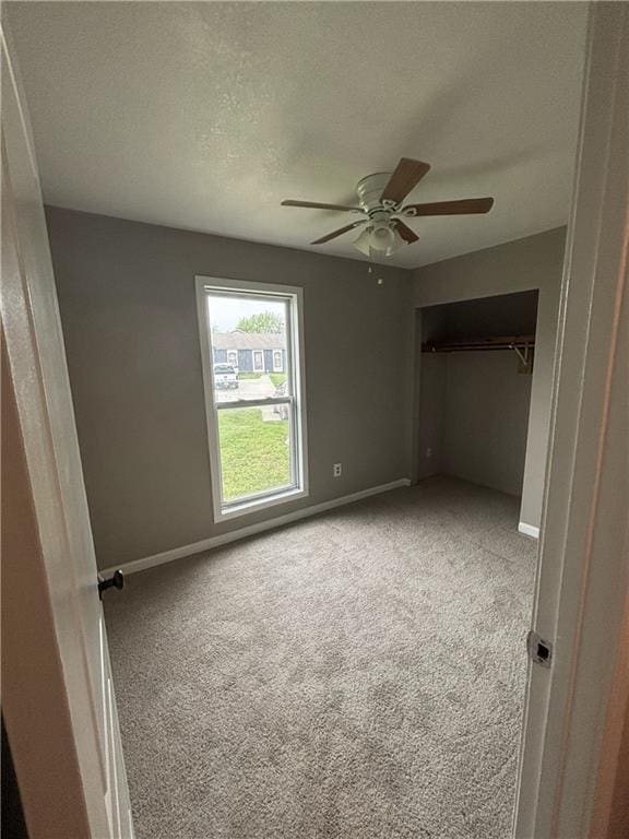 unfurnished bedroom featuring baseboards, a ceiling fan, and carpet
