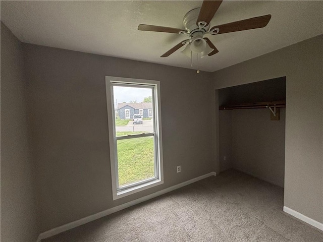 unfurnished bedroom featuring multiple windows, carpet, and baseboards