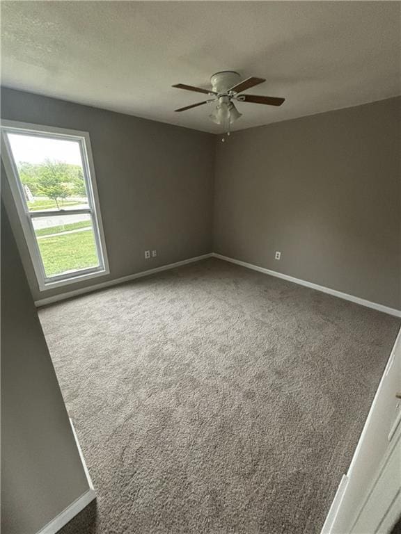 spare room featuring a ceiling fan, carpet flooring, and baseboards